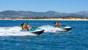 Dos motos de agua en la bahía de Santander con los arenales de Somo al fondo